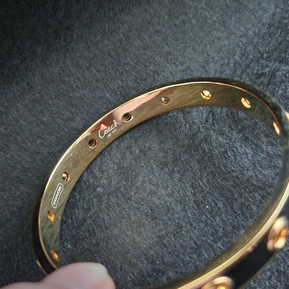 COACH black enamel and gold plated bangle bracelet with grommet design